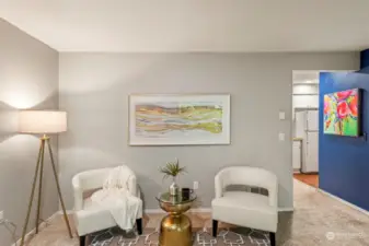 The view from the living room looking toward the hallway & kitchen. The guest bathroom is located behind the chairs.