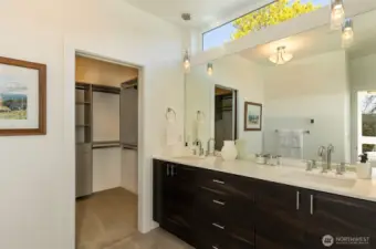 Dual sink vanity and walk-in closet with custom built-ins