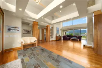 The dramatic entry ushers you toward the living room with a gas fireplace as the views draw you to the wall of windows beyond. The office is to the left of the living room and the second living room is to the right.  The two living spaces share a two-sided gas fireplace.
