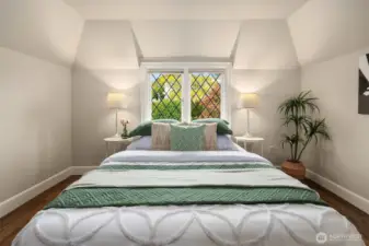 The third upstairs bedroom enjoys a leaded-glass outlook toward the front entry courtyard.