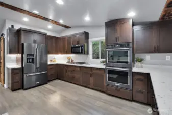 This gorgeous gourmet kitchen boasts of custom soft close cabinetry, under cabinet lighting, gas range and double oven.
