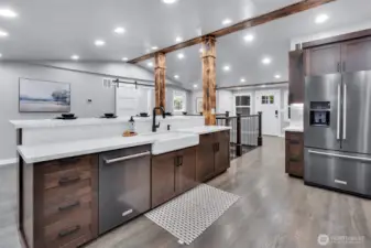 Large, oversized center island offers bar counter seating, built in white cast iron farm sink with goose neck faucet, storage and dishwasher.