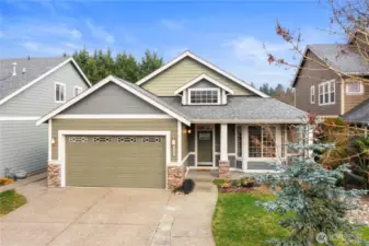 Classic curb appeal featuring a covered porch and attached two-car garage.