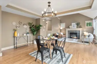 Dining room view looking into the living room featuring tray ceiling.