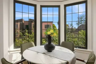 Large windows in every room including lovely dining space with expansive lush green and city views.