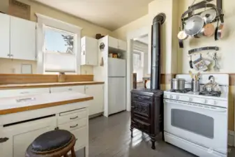 Gas cookstove, as well, and sleek butcher block counters and island.