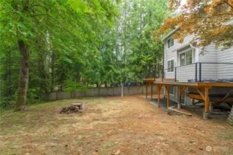 View of the large and private backyard, complete with a firepit area. You can walk down through the woods to the creek below. Waterfront without the taxes!