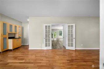 Hardwood floors in front living room with a gas fireplace to the right of this photo.  Butler's pantry shown to the left leading to the kitchen.