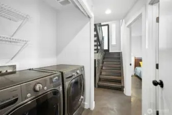 LG washer-dryer on lower level. Entry door is up those stairs. Photographer standing at garage door.