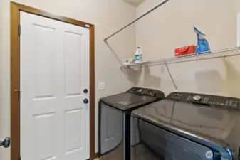 Laundry room with newer washer and dryer.  Door leads out to three car tandem garage.