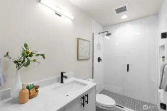 Luxurious en-suite bath with dual vanity and sleek tile finishes.