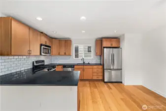 Slab granite peninsula bar has seating area for 3