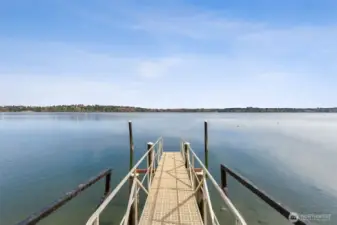 Standing here, you start to understand what makes this neighborhood so sought after. The private dock walkway gives you that easy, direct connection to Budd Inlet, where boating out to Olympia becomes part of the routine instead of a special occasion. Cruise over to the marina, grab dinner on the waterfront, or just take a slow evening ride as the sun drops behind the hills. The setting here does a lot of the work for you, wide open water, big sky, and that calm, coastal feel that defines this part of the South Sound.