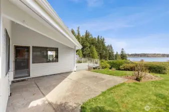 Rain or shine, this spot delivers. Just off the family room, the covered patio gives you a comfortable place to sit and take in the water view without worrying about the weather, which, let’s be honest, is a real advantage here. The concrete patio extends out and connects seamlessly to the deck, creating multiple zones for relaxing or entertaining. Around it, the lawn is open, sunny, and ready for whatever you want to add, garden beds, play space, or just a stretch of green to enjoy. It’s an easy, low-effort outdoor setup that still gives you plenty of flexibility.