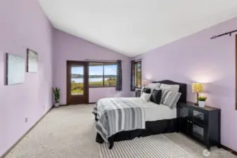 Waking up to this view is a pretty strong selling point. The primary suite carries those vaulted ceilings through, giving the room a sense of openness that pairs nicely with the water just beyond the window. A hinged door with a full mirrored panel reflects the light and keeps the view uninterrupted, which is a thoughtful detail you don’t always see. There’s plenty of space here for a king bed along with additional furniture, so it doesn’t feel tight or overfilled. The soft carpeting underfoot adds comfort, making this room feel like a true place to unwind at the end of the day.