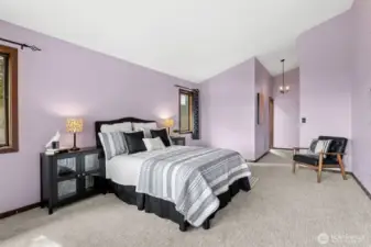 Windows on either side of the bed keep the space bright and connected to the outdoors, while still feeling calm and private. The transition toward the ensuite is easy and intuitive, with a hallway that feels integrated into the room’s design. Overhead, a chandelier adds a bit of character, bringing in that subtle vintage touch that ties back to the home’s original era without feeling out of place.