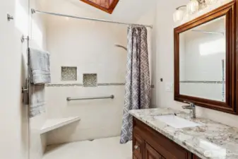 Easy entry, smart details, and plenty of light, this shower checks all the right boxes. The zero-threshold design makes it simple to step right in, while the built-in seat and grab bar add comfort and support when you want it. Tile surrounds keep things low maintenance, and the recessed niches give you a place for everything without clutter. Overhead, the wood-trimmed skylight brings in natural light that brightens the space in a really nice way.