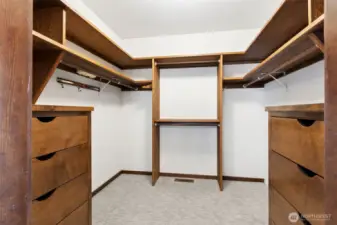 This closet feels more like a built-in system than an afterthought. Solid wood shelving and integrated drawers give everything a place, making it easy to stay organized without needing extra furniture or add-ons. The layout is clean and functional, with a mix of hanging space and storage that actually works for everyday use. Carpet underfoot keeps it comfortable and quiet, rounding out a space that feels finished and thoughtfully designed.