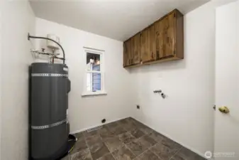 Water tank located in the laundry room that includes a washer/dryer hookup + cabinet space for added storage.