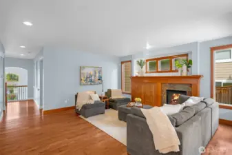 From the living room, view extends down the hallway toward the front door and formal living room. A powder room sits just to the left, while the entrances to the garage and mid-level bonus room are tucked around the corner to the right.