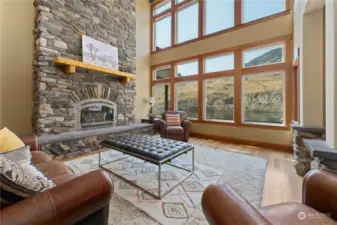 View 2 of living room w/ stone fireplace, vaulted ceilings, oversized windows and sliding glass doors leading to the waterfront deck and outdoor living area.