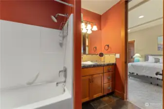 Lower level bedroom 4 w/ on-suite bath and glass sliding doors leading to the outdoor living area.