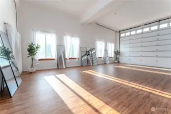 View 2 of attached garage w/ oversized doors and yoga/exercise room and lounge area.