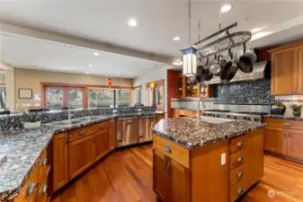 Kitchen view 2 w/ Viking® Professional appliances, wood cabinetry, walk-in pantry and granite countertops, overlooking the view dining room and Great Room w/ glass sliding doors that open onto the waterfront deck and outdoor living area.