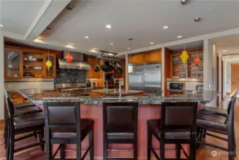 Kitchen view 3 w/ Viking® Professional appliances, w/ sit up bar, wood cabinetry, walk-in pantry and granite countertops. overlooking the view dining room and Great Room w/ glass sliding doors that open onto the waterfront deck and outdoor living area.