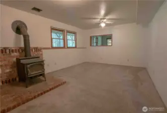 Lower living room with wood stove. Could be a game room, TV room or ?