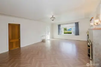 Step into the large living area with eastward facing windows. Third bedroom entrance pictured on left.