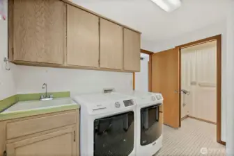 Back to the kitchen and through the family room, enter the laundry room.  The laundry room is the hub of this house, so to speak, leading to a powder room and a hallway which leads to the garage, another access to the deck and to the stairway that goes downstairs.  I'd like to also draw attention to the utility sink, which is appreciated most especially if you don't have one.