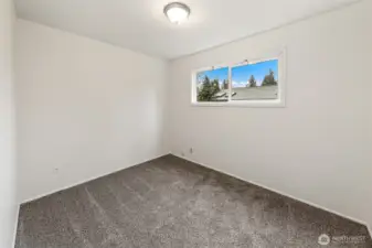 A comfortable and flexible bedroom offering space for a nursery, playroom, or quiet work-from-home retreat.