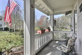 Enjoy the tranquil view from the front porch, overlooking the meticulously maintained front yard cared for by the HOA.