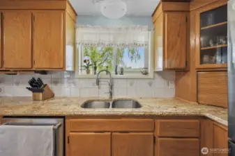 Double stainless sink overlooks the back farmland and deck.