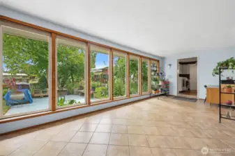 This wall of windows offers so much natural light in this secondary living space. Tile adorns most of the are.