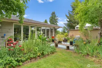 Patio space in side yard. Lots of beautiful flowers and perennials.