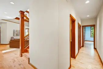 Hallway to the primary bedroom, half bath, & laundry room