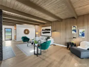 The living room is spacious with modern cool toned wood accents creating a warm and welcoming atmosphere.