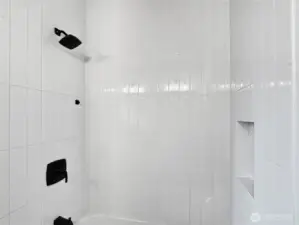 Tiled shower with recessed cubby in the main full bathroom