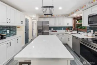 The kitchen has been beautifully updated in 2024 with new cabinets, sleek stone counters, and a striking tile backsplash. A spacious center island with outlets offers both function and style, making this the heart of the home.