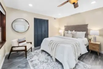 The primary bedroom offers impressive space, easily accommodating a king-size bed along with a large dresser. A folding-door closet painted in the home’s signature slate blue adds both function and style, continuing the home’s cohesive design.