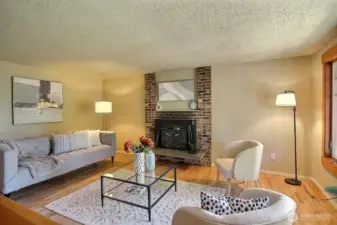 A spacious and inviting room, featuring a stunning wood fireplace with a striking brick centerpiece, creating an inviting and welcoming atmosphere.