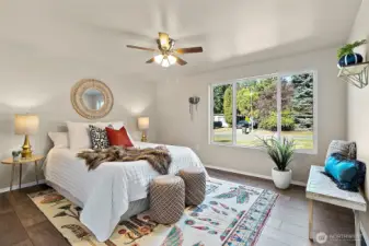 Unwind in the spacious primary bedroom, complete with a ceiling fan for comfort and fresh new lighting that adds a soft, welcoming glow.