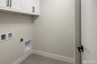 Laundry room on upper floor with built in cabinets and sink