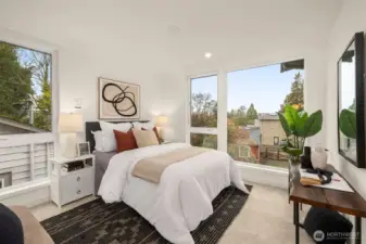 Spacious primary suite offering a peaceful retreat with large windows and plenty of room for a king-sized set.
