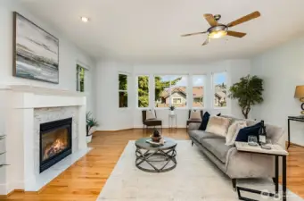 Extra large living area with many windows, ceiling fan and cozy gas fireplace