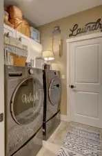 Utility room with front loading washing machine and dryer and cabinets for extra storage