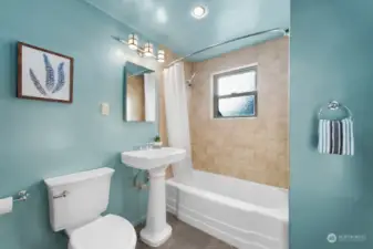 The full bath features a tub/shower combination with handsome tile tub-surround and a tile floor. There is a great bathroom cabinet (not shown) opposite the tub with room for all your toiletries and bathroom supplies.