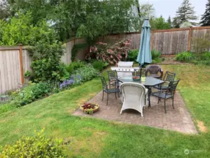 The backyard is large and fully fenced for great privacy. Here you can see the trees, garden areas and flower beds for greenery and color spots all summer long.